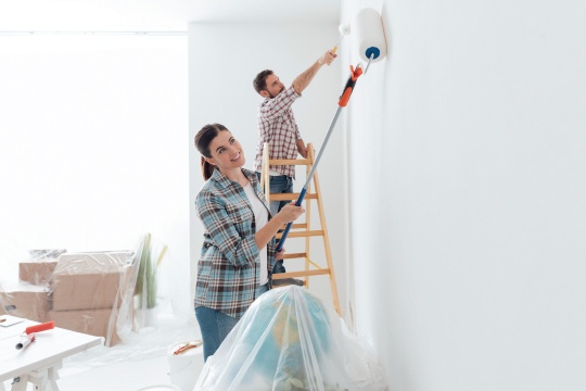 Couple painting a room in their house